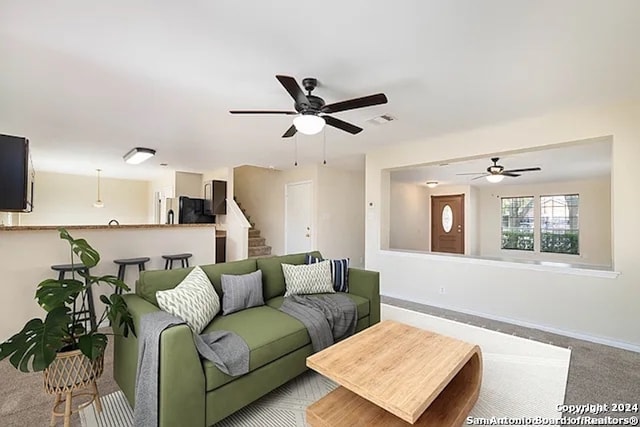 carpeted living room featuring ceiling fan