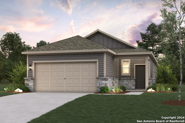 view of front of home with a garage and a lawn