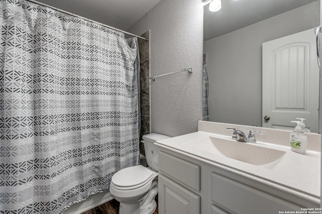 bathroom featuring walk in shower, vanity, and toilet