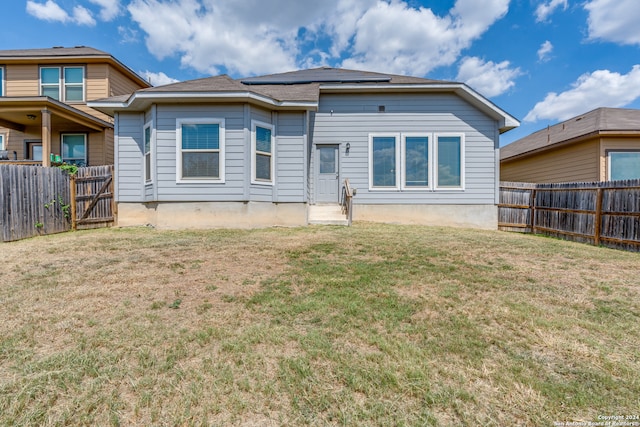 rear view of house featuring a yard