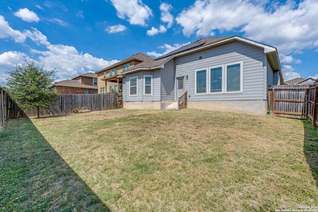 rear view of property featuring a lawn