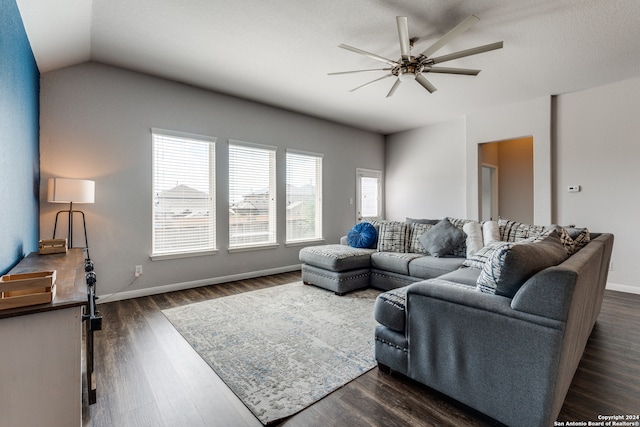 living room with ceiling fan, vaulted ceiling, and dark wood-type flooring