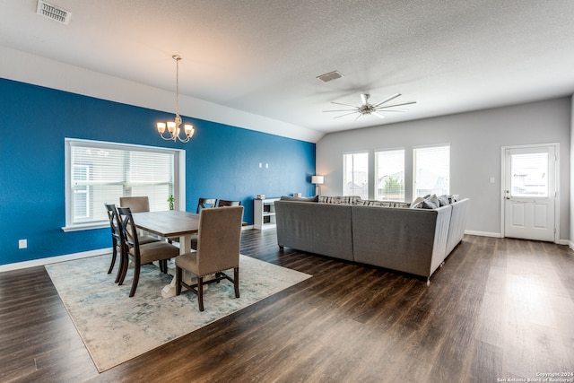 dining space featuring a textured ceiling, ceiling fan with notable chandelier, lofted ceiling, and dark hardwood / wood-style flooring