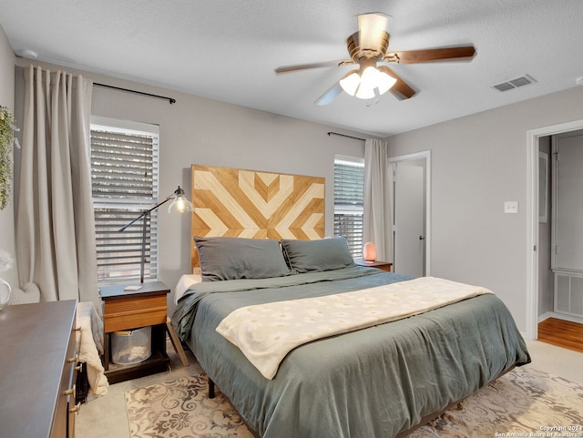 bedroom with a textured ceiling and ceiling fan