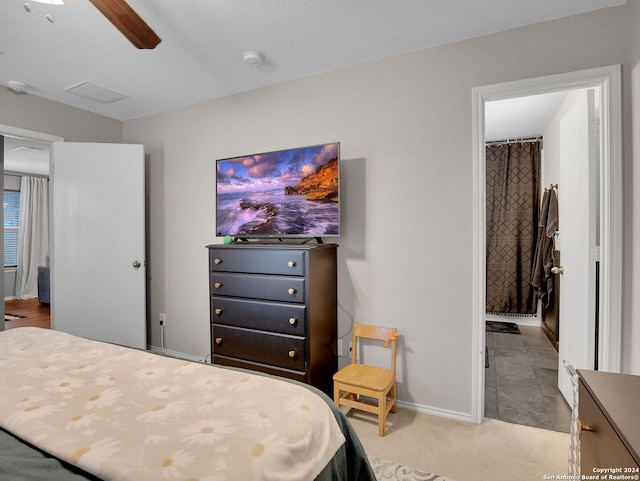 carpeted bedroom with ceiling fan and a textured ceiling