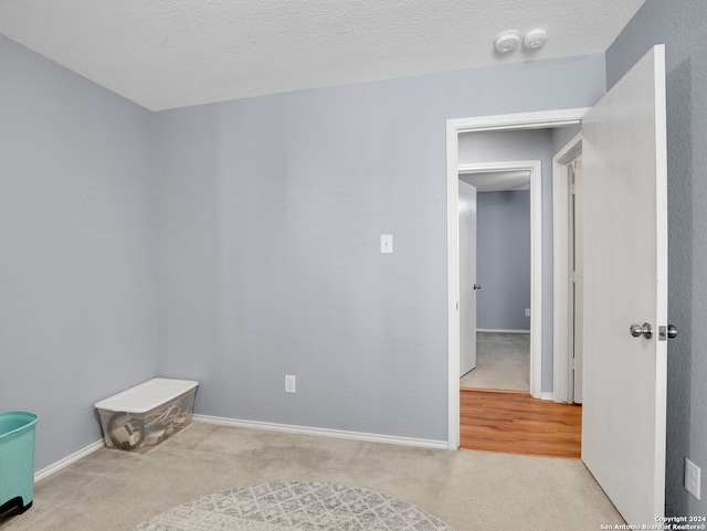 carpeted empty room featuring a textured ceiling