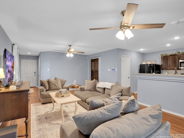 living room with light wood-type flooring and ceiling fan