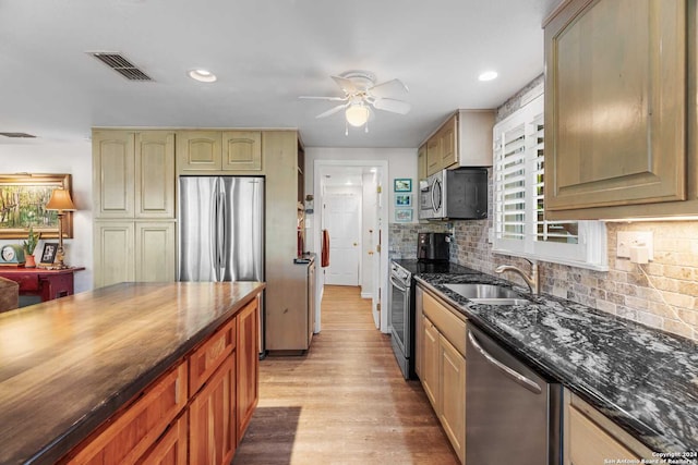 kitchen featuring light hardwood / wood-style floors, sink, backsplash, appliances with stainless steel finishes, and ceiling fan