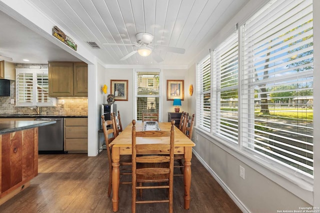 dining room with ceiling fan, sink, dark wood-type flooring, and crown molding