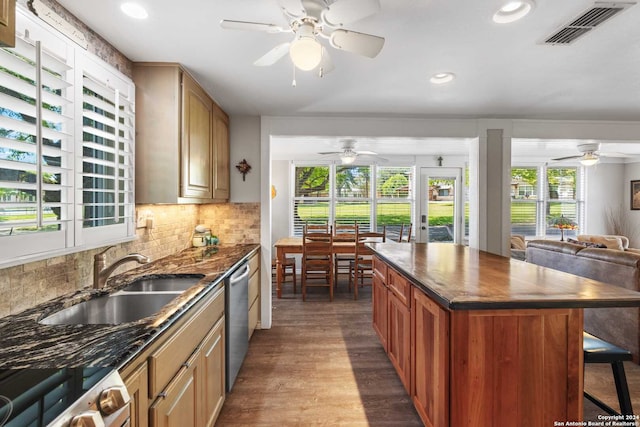 kitchen featuring sink, tasteful backsplash, stainless steel appliances, a center island, and dark hardwood / wood-style flooring