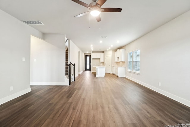 unfurnished living room with dark hardwood / wood-style floors and ceiling fan