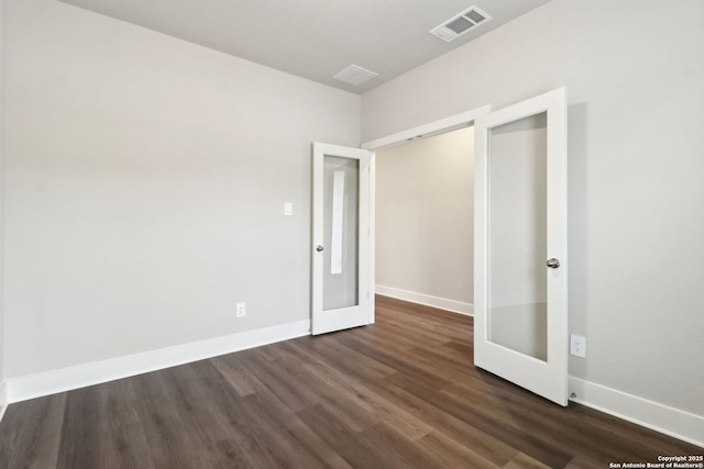 unfurnished bedroom with dark hardwood / wood-style flooring and french doors