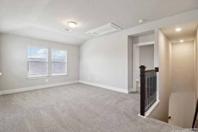 empty room with vaulted ceiling and carpet flooring