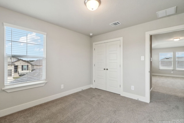 unfurnished bedroom featuring light colored carpet and a closet