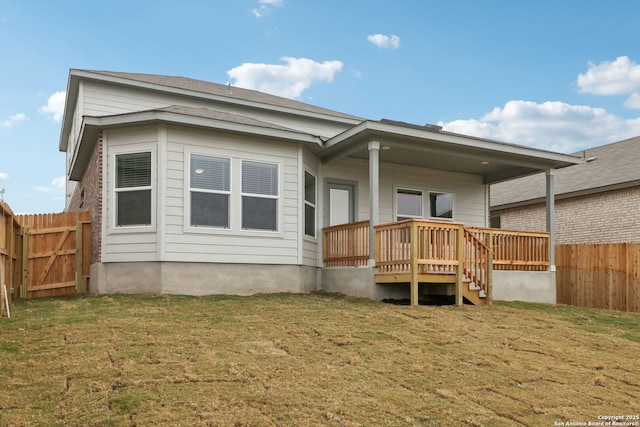 rear view of house featuring a wooden deck and a yard