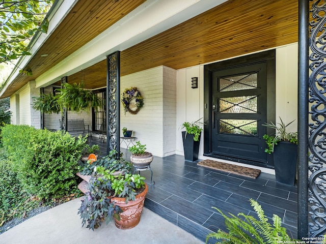 view of exterior entry featuring covered porch