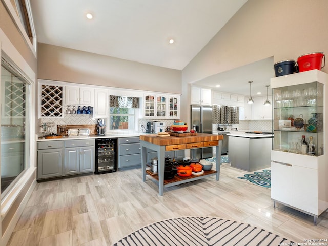 kitchen with gray cabinets, pendant lighting, beverage cooler, a kitchen island, and white cabinets