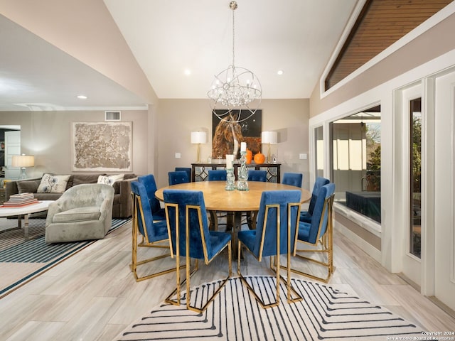 dining area featuring a notable chandelier, lofted ceiling, and light wood-type flooring