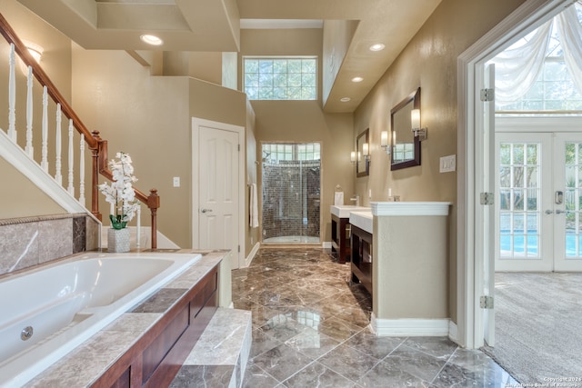 bathroom with vanity, french doors, and separate shower and tub