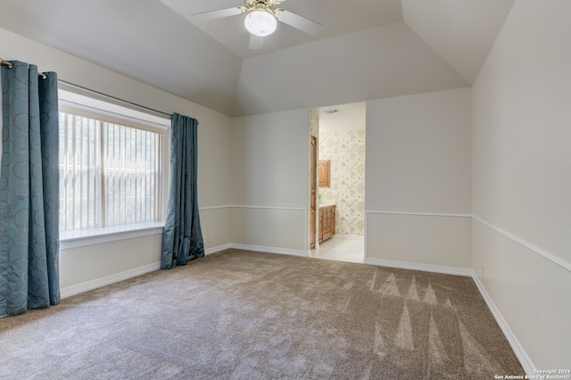 empty room featuring lofted ceiling, light colored carpet, and ceiling fan