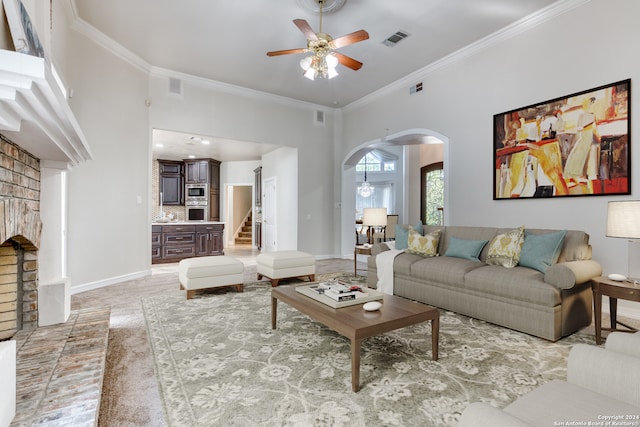 living room with ornamental molding, a fireplace, and ceiling fan