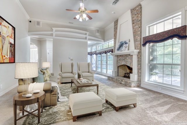 living room featuring crown molding, a brick fireplace, carpet floors, and ceiling fan