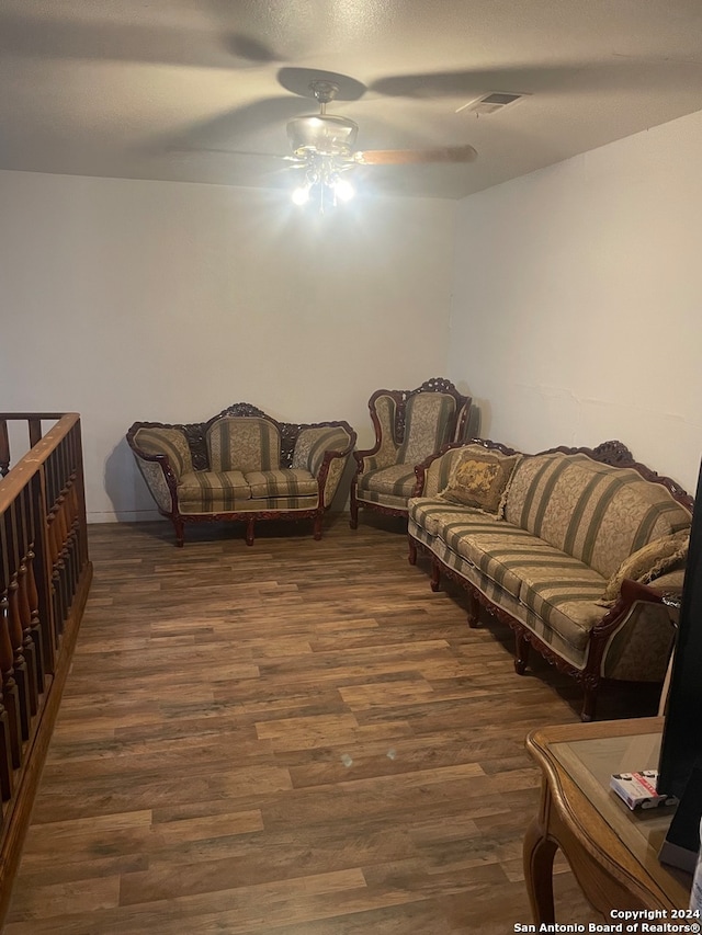 living room with ceiling fan and dark wood-type flooring