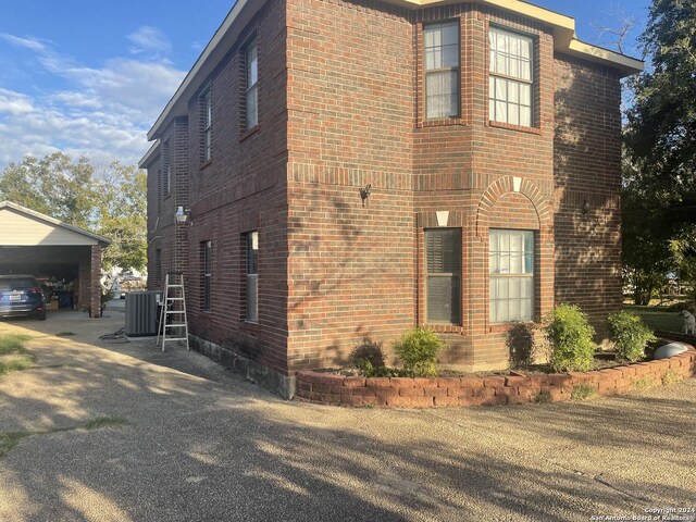 view of home's exterior featuring cooling unit, a garage, and a carport