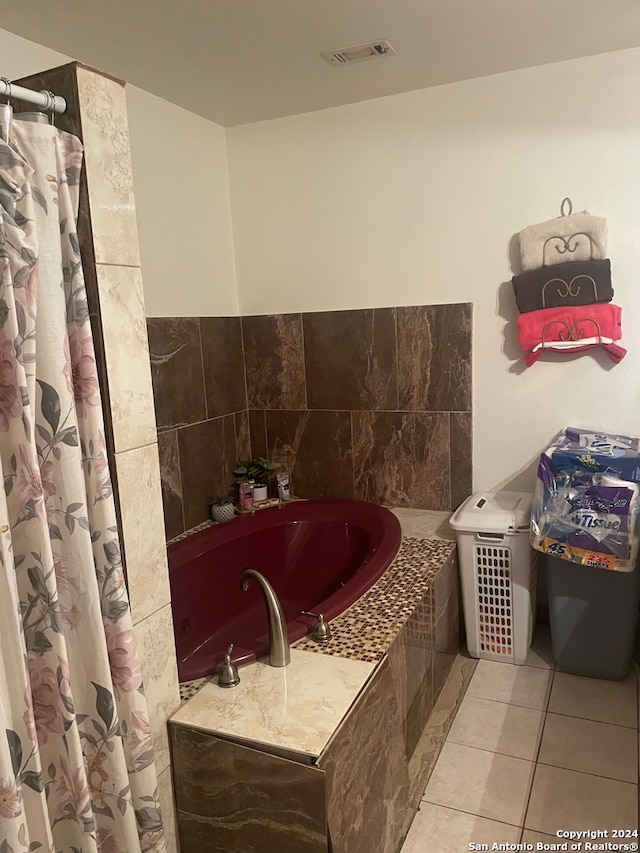 bathroom featuring tile walls, tile patterned floors, and a relaxing tiled tub