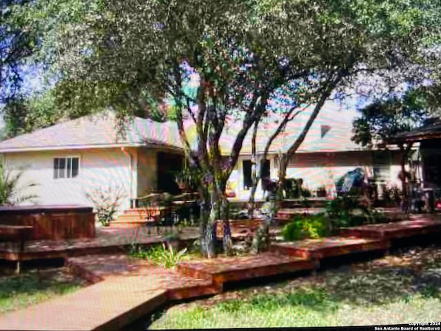 back of house featuring a jacuzzi