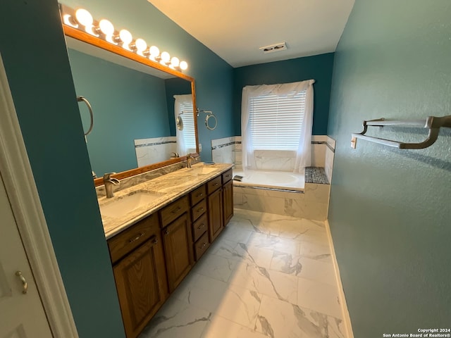 bathroom with vanity and tiled tub