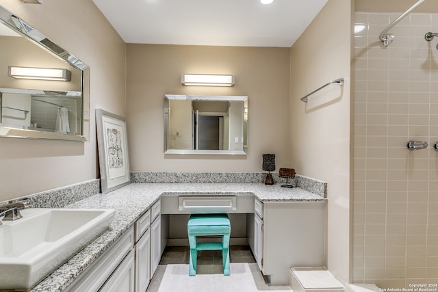 bathroom featuring tile patterned floors, vanity, and tiled shower