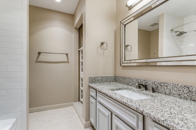 bathroom featuring tiled shower and vanity