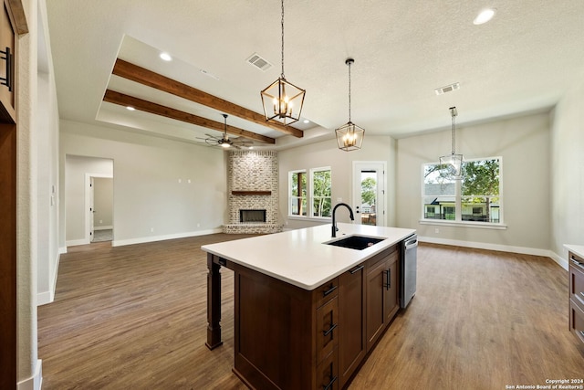 kitchen featuring dishwasher, beamed ceiling, sink, a center island with sink, and dark hardwood / wood-style flooring