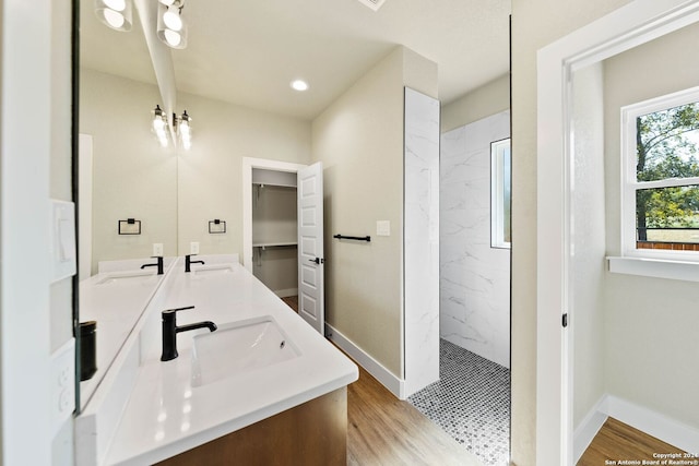 bathroom with vanity, hardwood / wood-style floors, and tiled shower