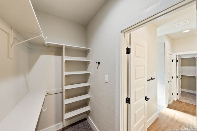 spacious closet with hardwood / wood-style flooring