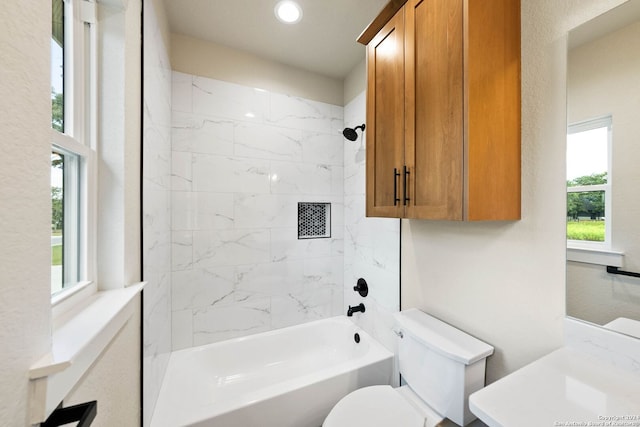 full bathroom with tiled shower / bath combo, vanity, and toilet