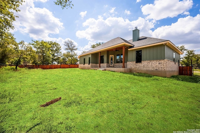 rear view of property featuring a lawn