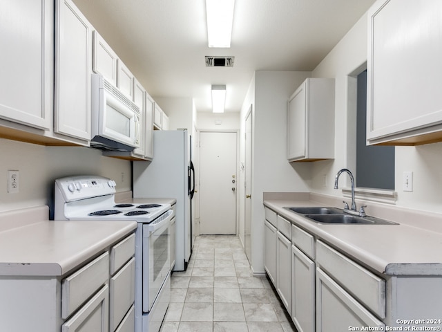 kitchen featuring white appliances, white cabinetry, and sink