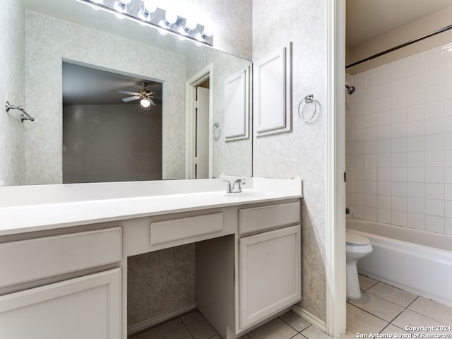 full bathroom featuring tile patterned floors, vanity, ceiling fan, tiled shower / bath, and toilet