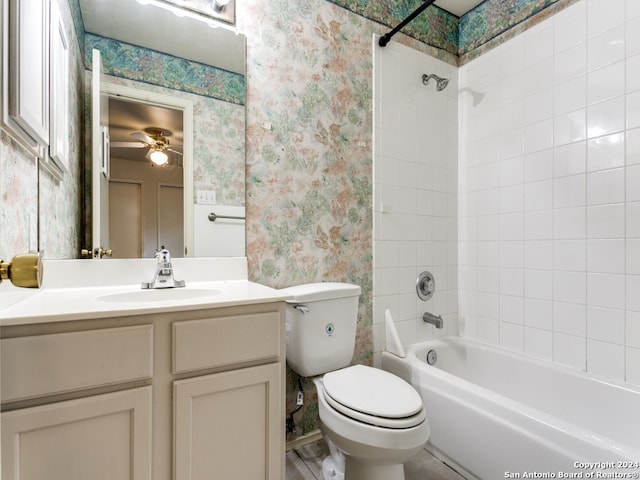 full bathroom with ceiling fan, vanity, tiled shower / bath combo, and toilet