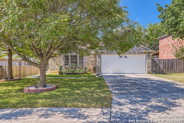 view of property hidden behind natural elements with a garage and a front lawn