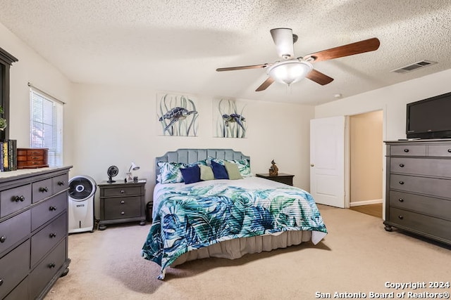 carpeted bedroom with a textured ceiling and ceiling fan