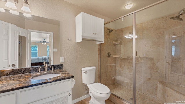 bathroom featuring ceiling fan, an enclosed shower, vanity, and toilet