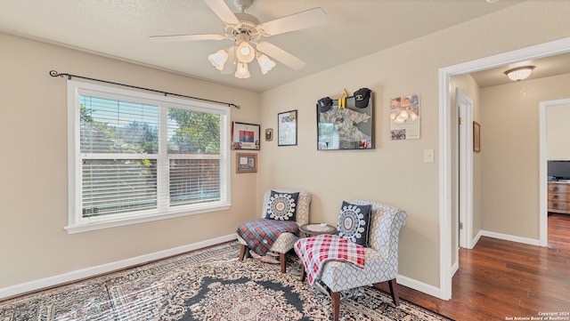 sitting room featuring ceiling fan and dark hardwood / wood-style floors