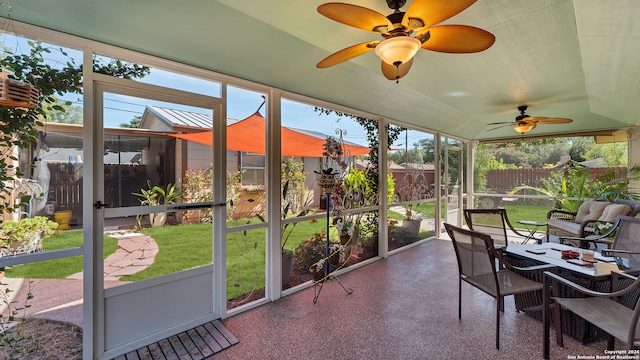 sunroom / solarium with ceiling fan and vaulted ceiling