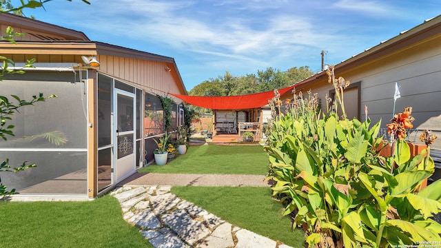 view of yard featuring a sunroom and a patio