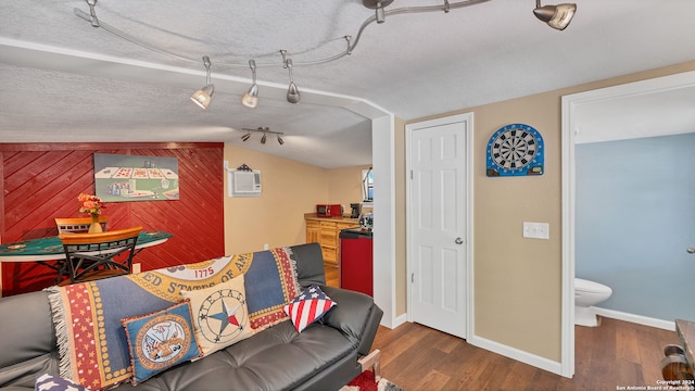 living room featuring wooden walls, vaulted ceiling, a textured ceiling, and dark wood-type flooring