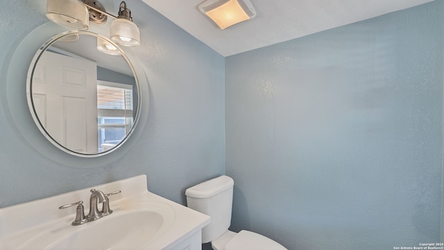 bathroom with vaulted ceiling, vanity, and toilet