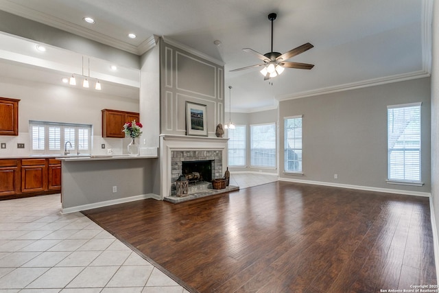 unfurnished living room featuring crown molding, a ceiling fan, light tile patterned flooring, a fireplace, and recessed lighting